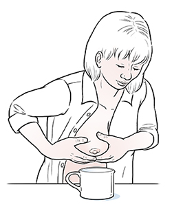 Eine Frau, die Muttermilch mit der Hand abpumpt.