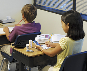 Girl checking blood sugar at school.