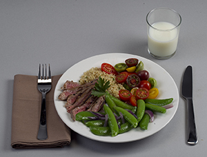 肉、野菜、でんぷんのバランスの取れたディナープレートと、ミルクの入ったグラス。
